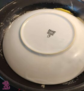 Pfannkuchen wird über Teller gewendet